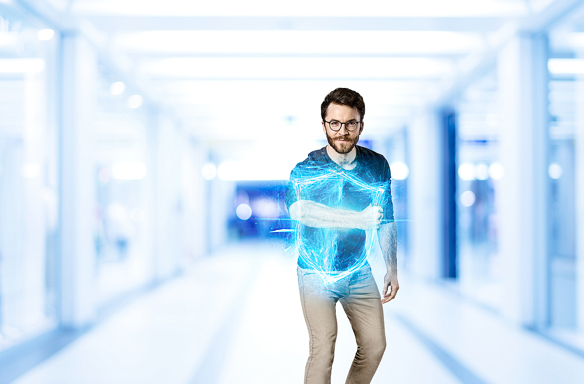 Ein Mann mit Bart und Brille zeigt ein digitales Schild als Hologramm