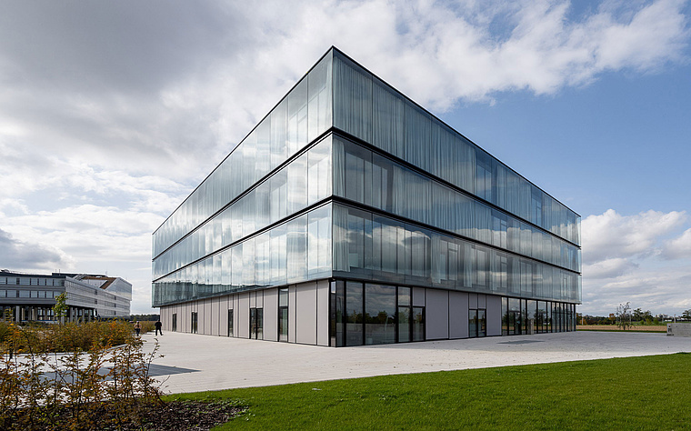 Modernes Bürogebäude der baramundi SoftwareFactory mit Glasfassade und grüner Umgebung
